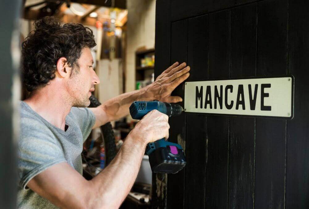 Man using drill to put a mancave sign